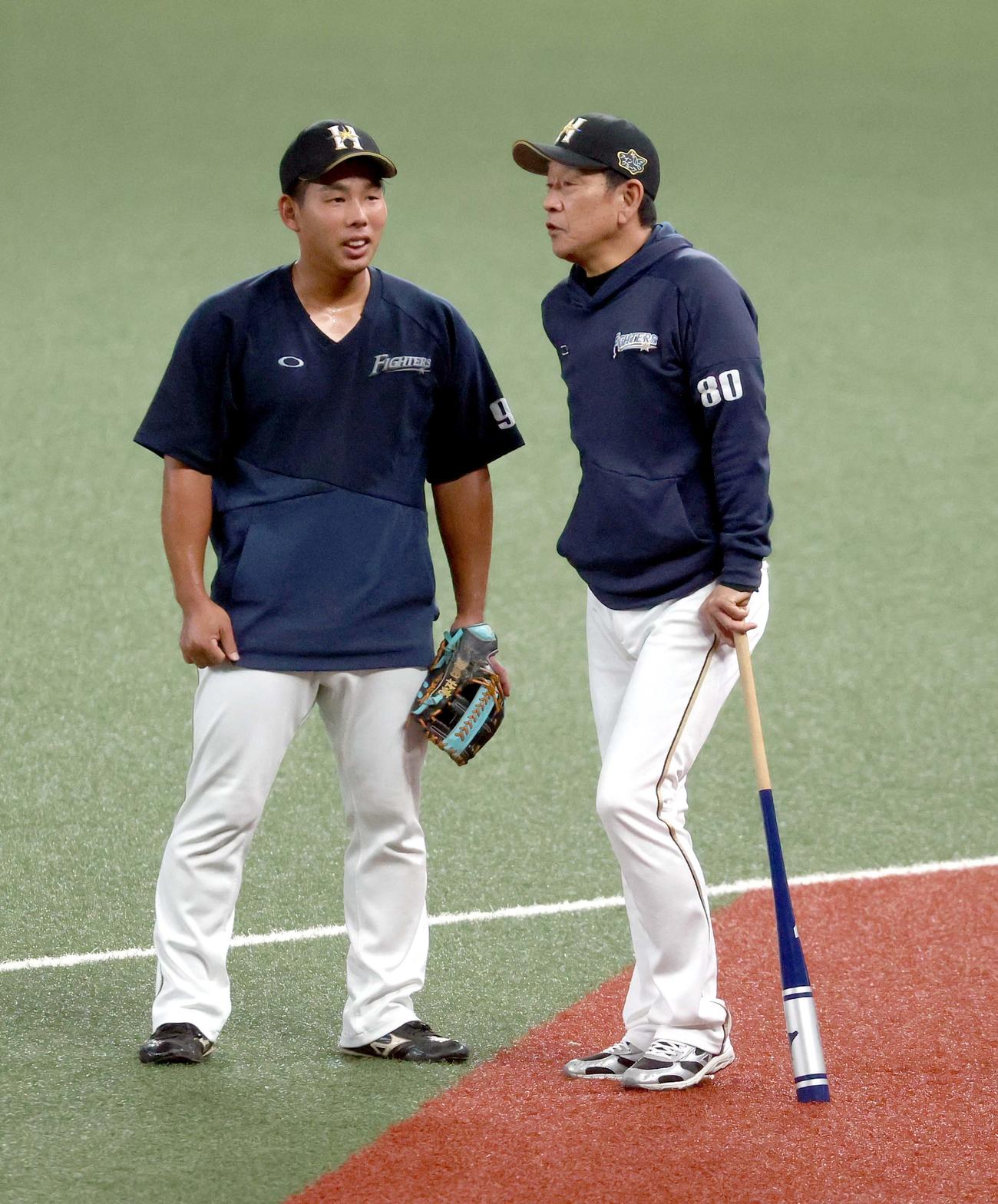 西武対日本ハム　試合前、会話をする日本ハム樋口と栗山監督（右）（撮影・佐藤翔太）