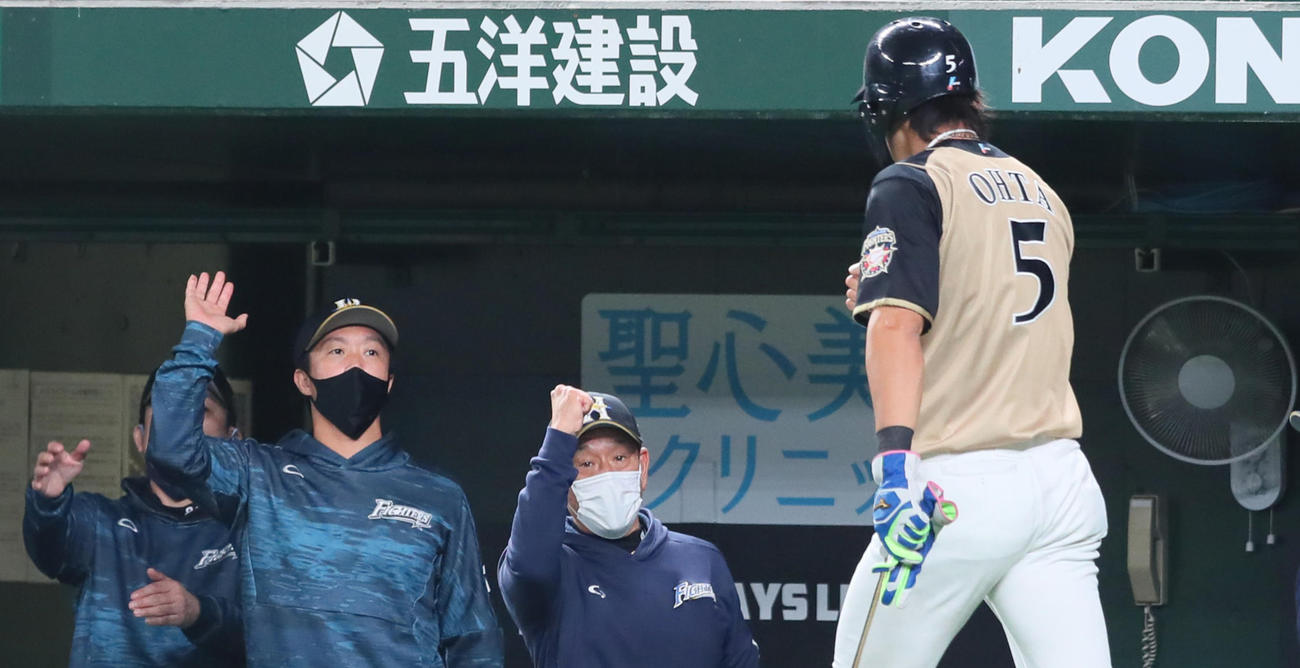 西武対日本ハム　2回表日本ハム1死満塁、西川の中犠飛で生還した大田（右から2人目）をガッツポーズで迎える栗山監督（中央）（撮影・足立雅史）
