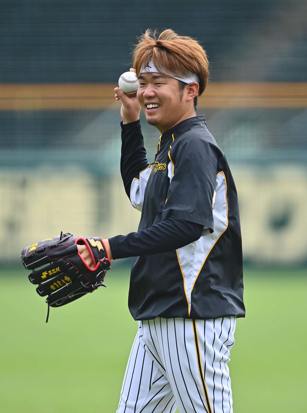 笑顔を見せながらキャッチボールをする西勇輝（撮影・上田博志）