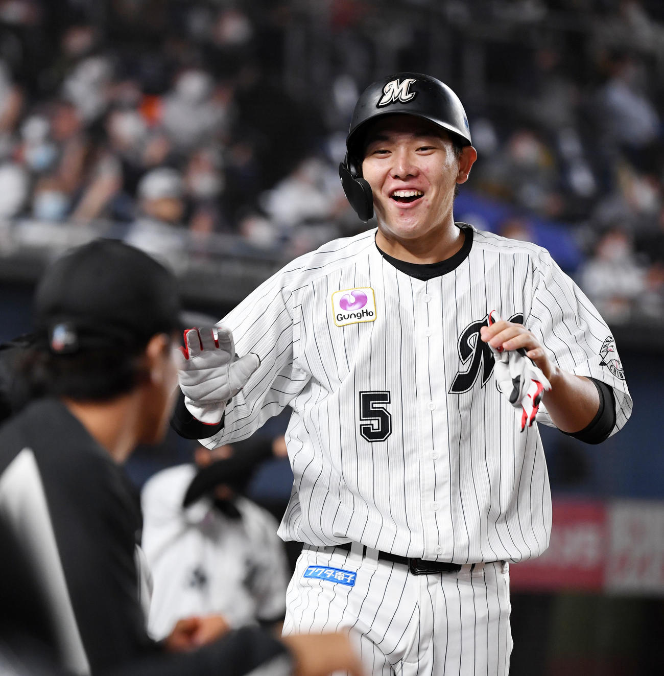 ロッテ対ソフトバンク　2回裏終了時、笑顔でナインとタッチを交わす安田（撮影・横山健太）