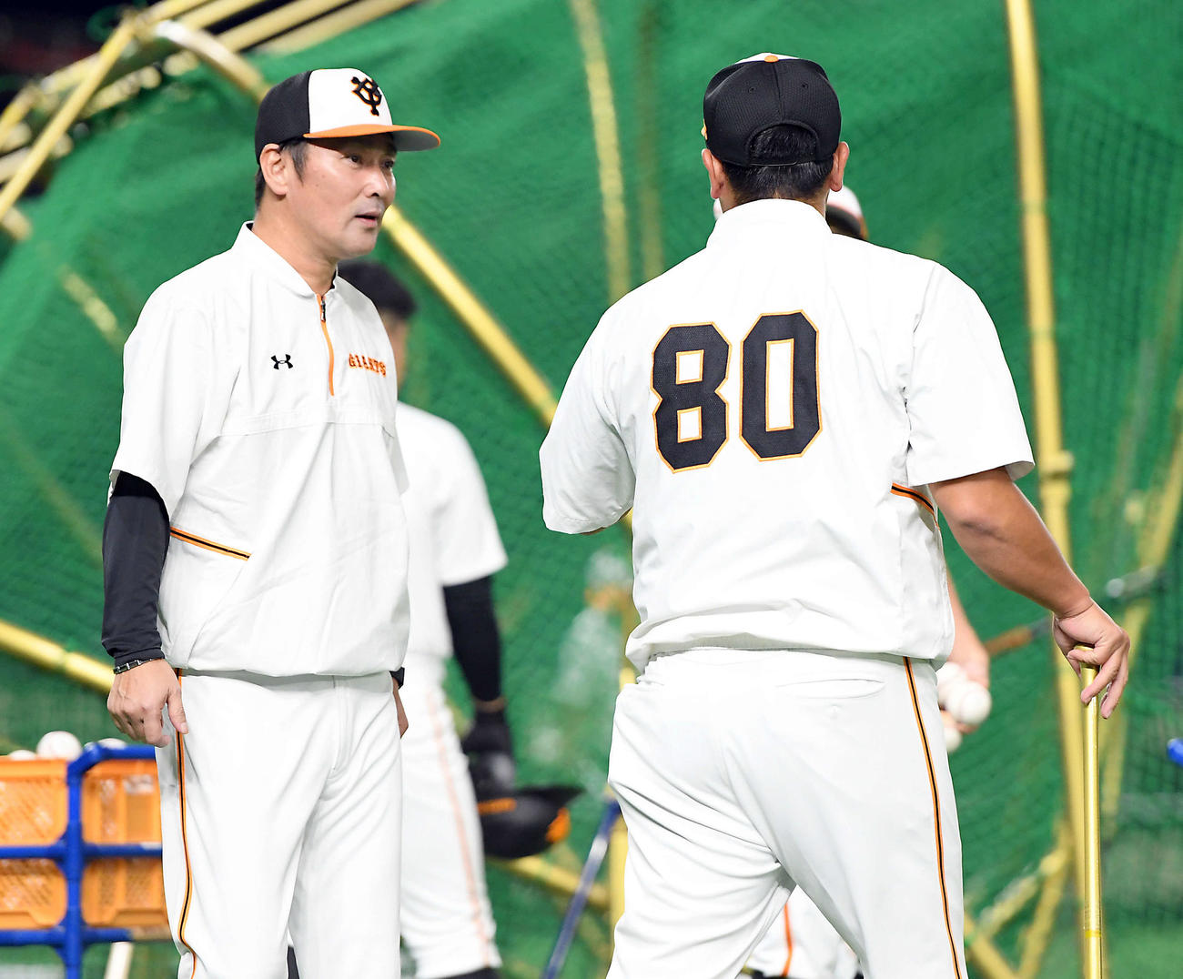 グラウンドに姿を見せた巨人元木ヘッドコーチは、阿部ヘッドコーチ代行と話をする（撮影・たえ見朱実）