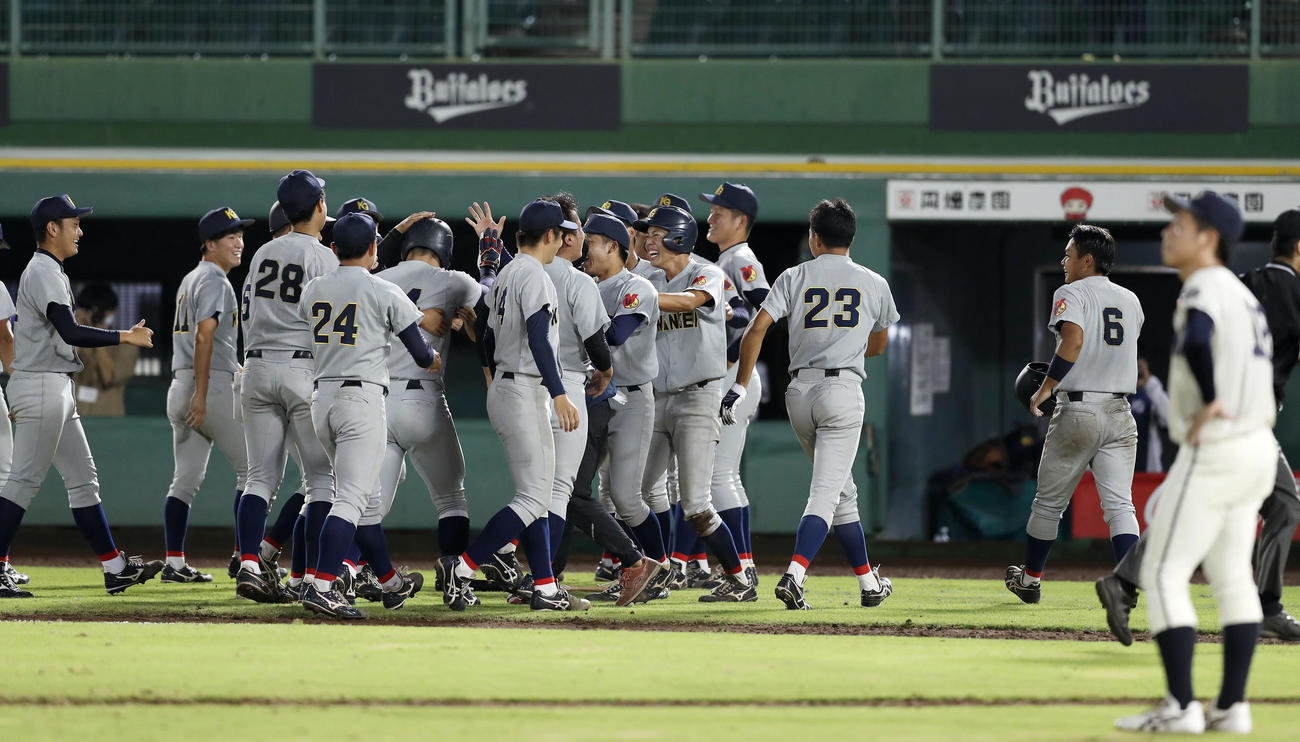 同大対関学大　10回裏関学大1死二、三塁、石井の2点滴時打でサヨナラ勝ちし、ベンチを飛び出して喜ぶ関学大ナイン。手前右は肩を落とす同大・高橋（撮影・前田充）