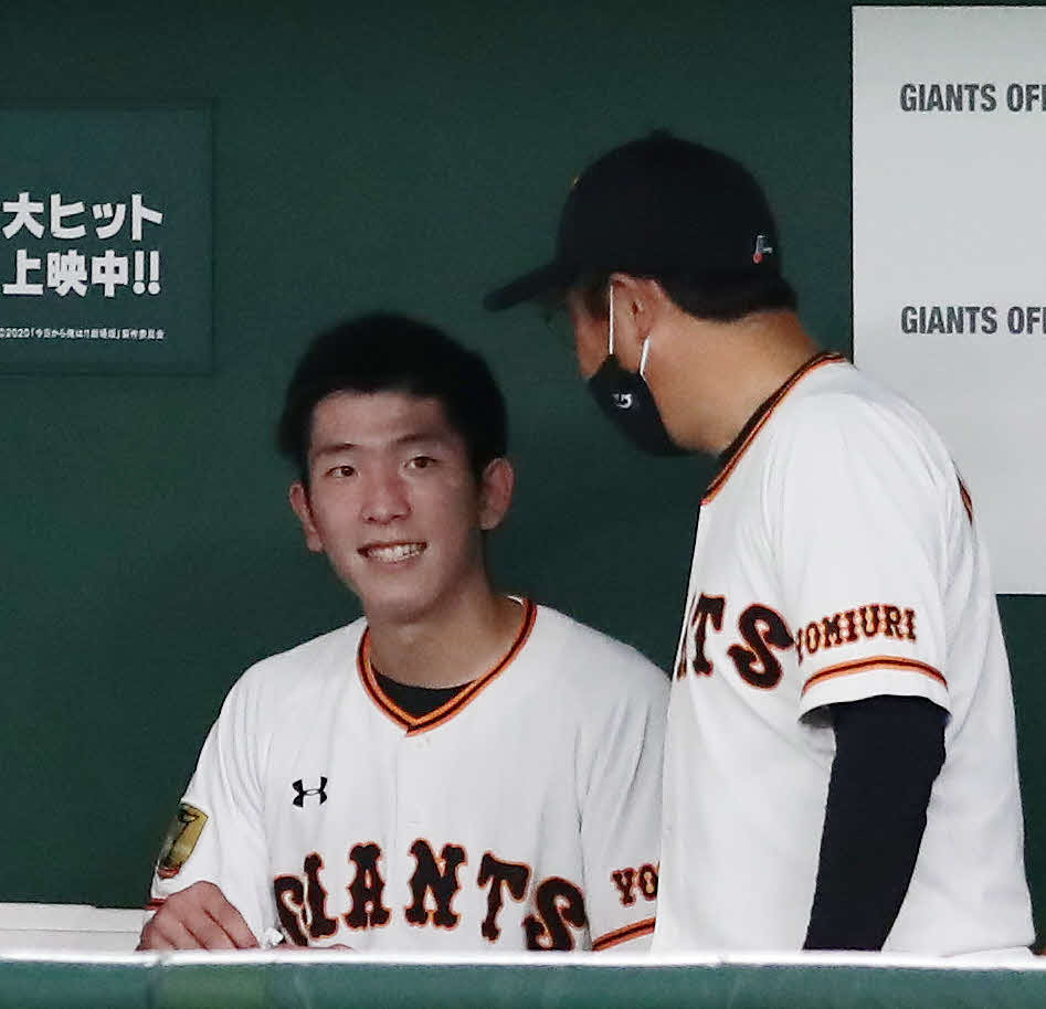 巨人対中日　7回を投げ終え、宮本コーチ（右）に声をかけられ笑顔をみせる戸郷（撮影・丹羽敏通）