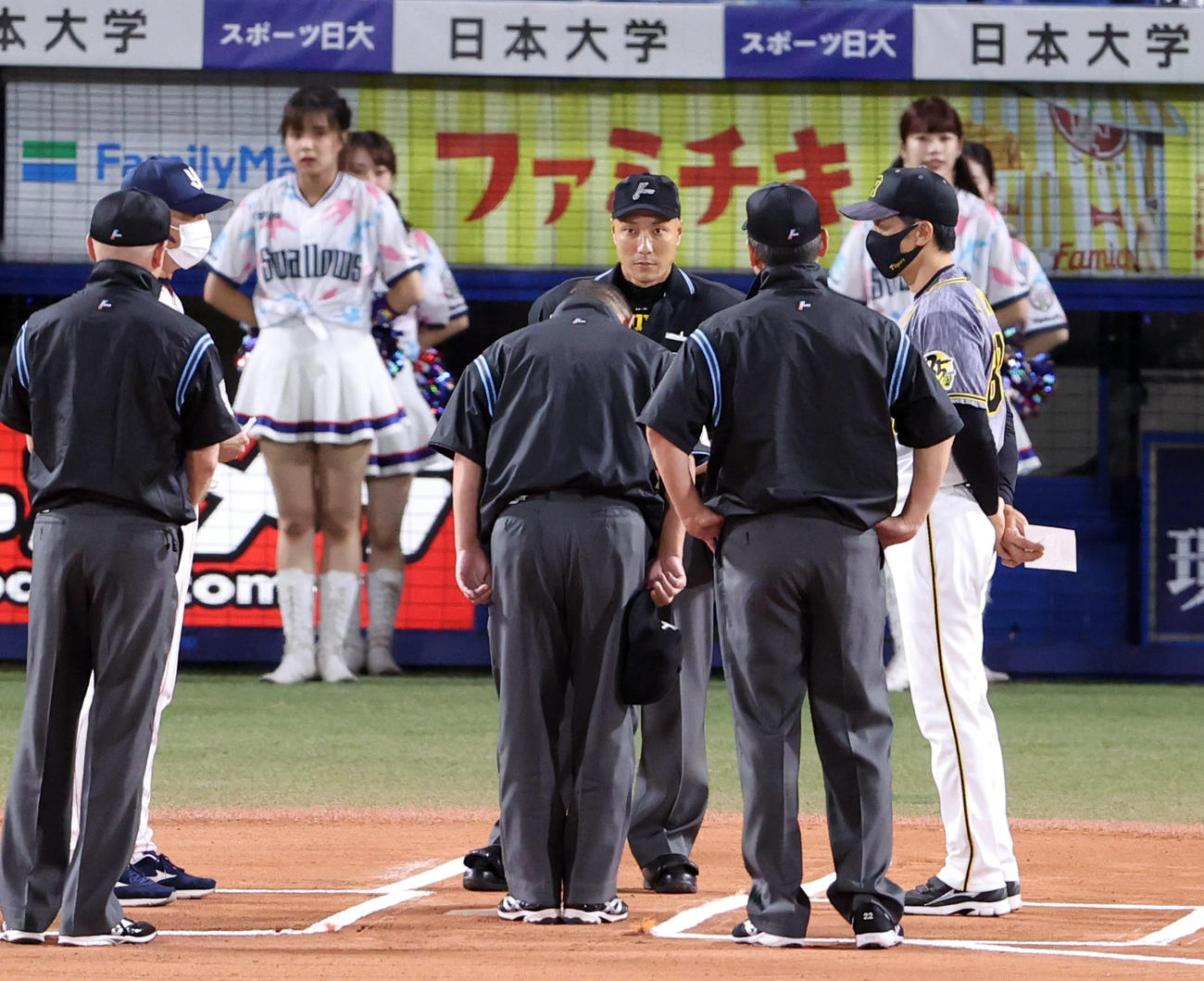 ヤクルト対阪神　試合前のメンバー表確認で、キャップを取り、矢野監督（右）の前で深々と一礼する森審判（手前）（撮影・狩俣裕三）