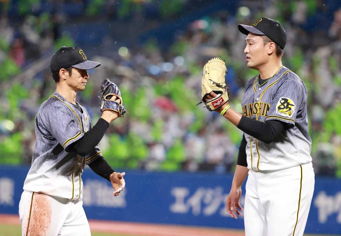 ヤクルト対阪神　2回、好守をみせた中堅近本光司（左）とタッチを交わす秋山拓巳（撮影・清水貴仁）