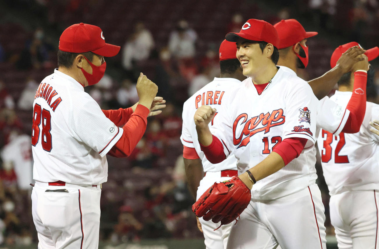 広島対DeNA　完封勝利を挙げた九里（右）は佐々岡監督に迎えられる（撮影・加藤孝規）