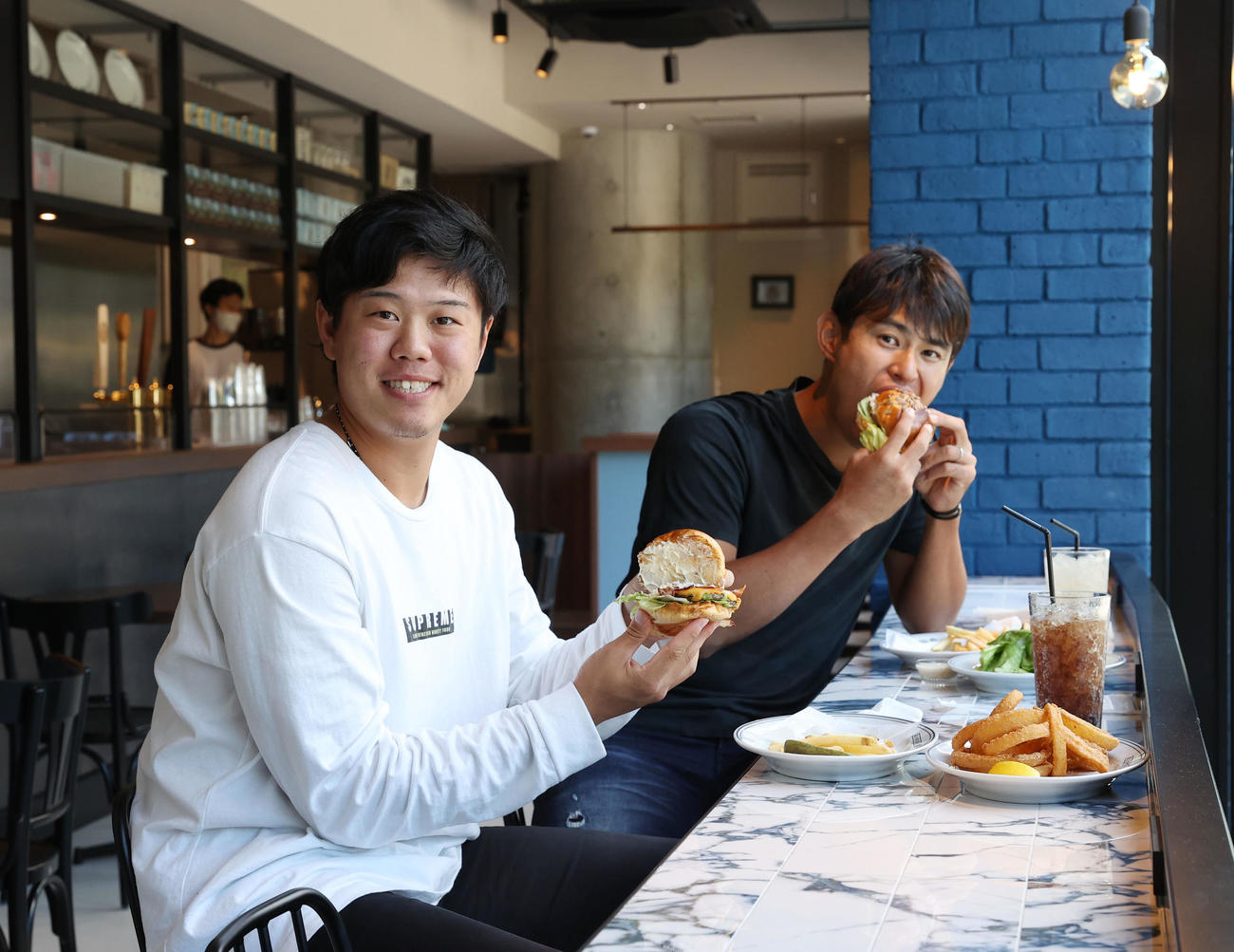 横浜スタジアム新店舗「BALLPARK　BURGER　＆9」プレス向け内覧会でハンバーガーを試食するDeNA上茶谷（左）と井納（撮影・垰建太）