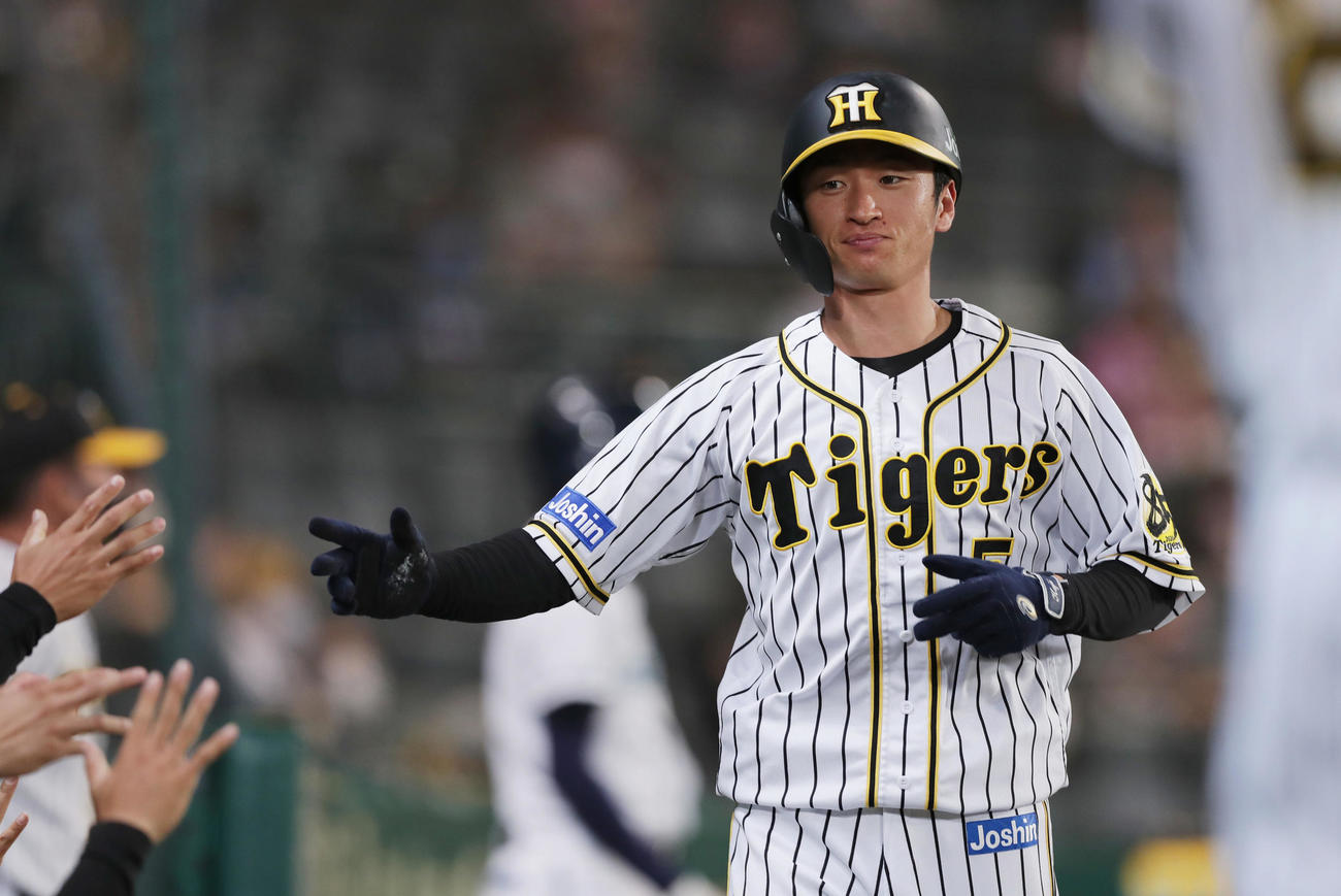 阪神対中日　1回裏阪神2死三塁、勝野の暴投で先制の生還を果たし、ナインに迎えられる近本（撮影・前田充）