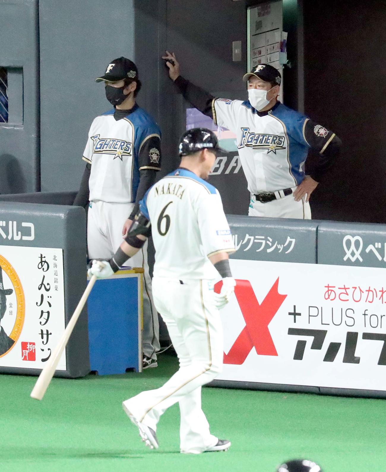 日本ハム対ロッテ　ベンチで険しい表情の日本ハム栗山監督。左手前は中飛に終わりベンチに戻る中田（撮影・佐藤翔太）