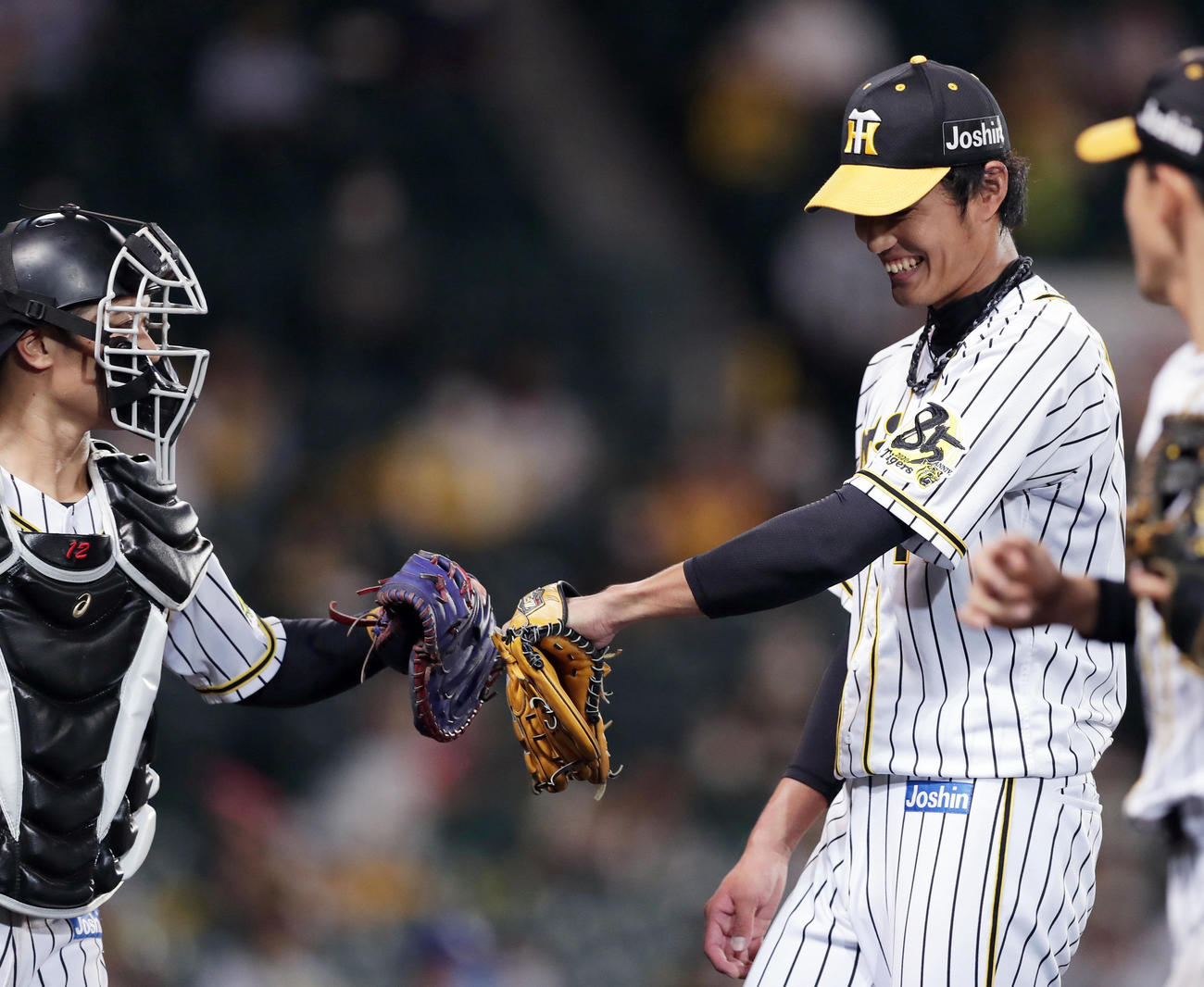 阪神対中日　8回表の中日打線を抑えた藤浪（右）は坂本に迎えられ笑顔を見せる（撮影・前田充）