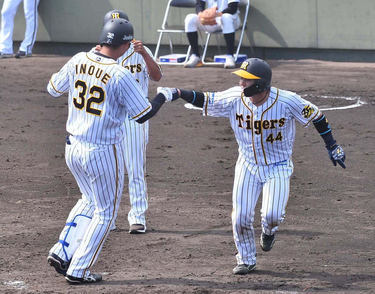 ウエスタン・リーグ　阪神対オリックス　3回裏阪神2死二塁、同点2点本塁打を放つ井上（左）は梅野とグータッチ（撮影・上田博志）