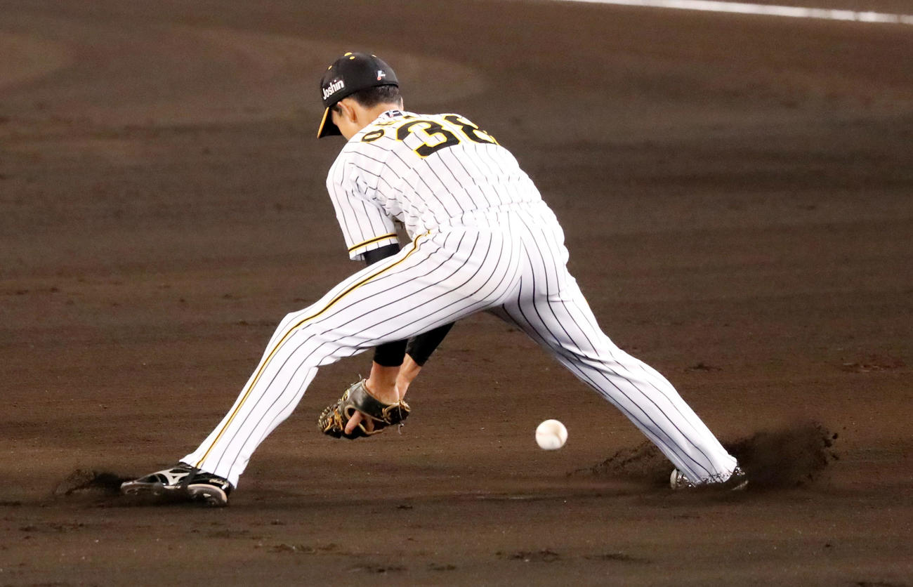 阪神対中日　1回表中日無死一塁、小幡は京田の打球をトンネルする（撮影・加藤哉）