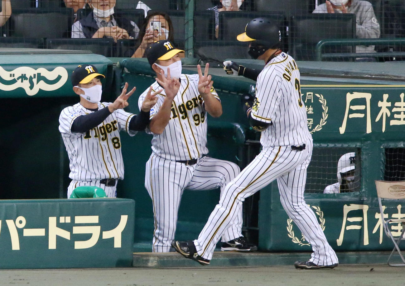 阪神対巨人　2回裏阪神無死、大山（右）は左中間越え本塁打を放ち矢野監督（左）らから出迎えられる（撮影・上山淳一）