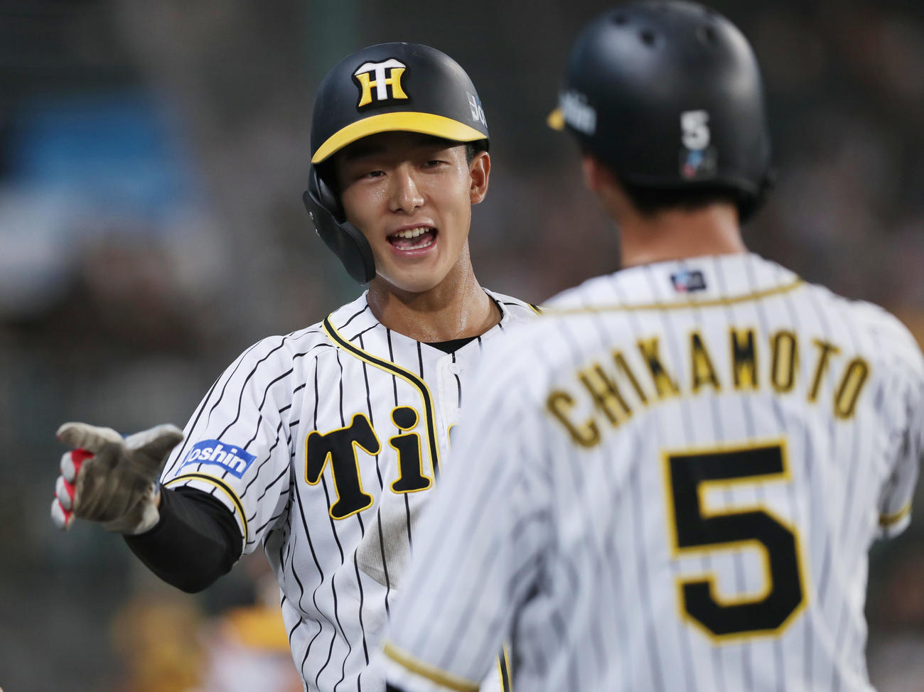 阪神対巨人　5回裏阪神1死満塁、糸井の2点適時打で生還しナインに迎えられる小幡（左）と近本（撮影・前田充）
