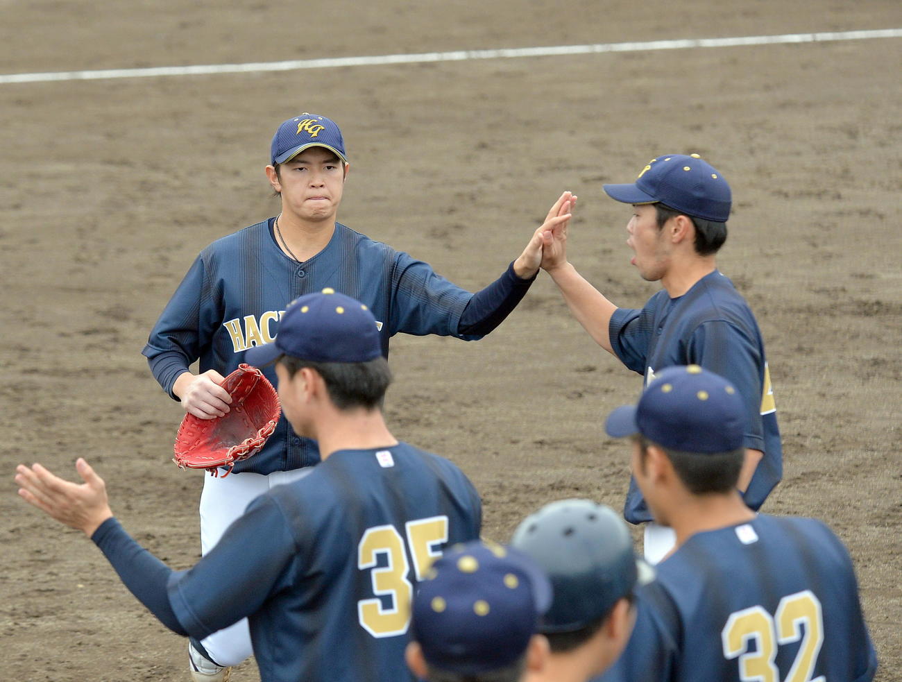 八戸学院大対青森大　仲間にハイタッチで迎えられる八戸学院大・大道（中央）（撮影・鎌田直秀）