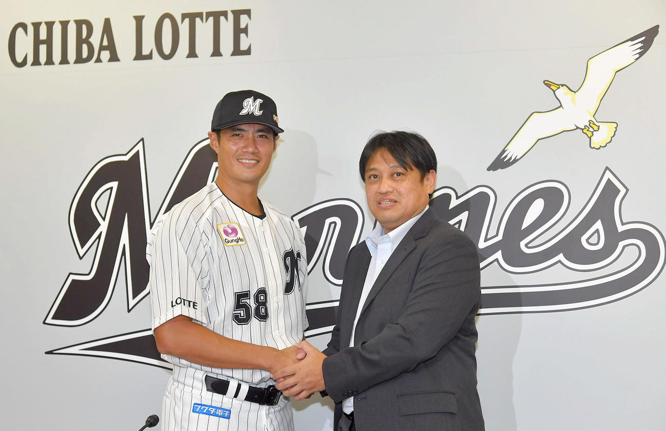 ロッテ入団会見を行い、松本尚樹球団本部長と握手するチェン・ウェイン投手（左）（代表撮影）