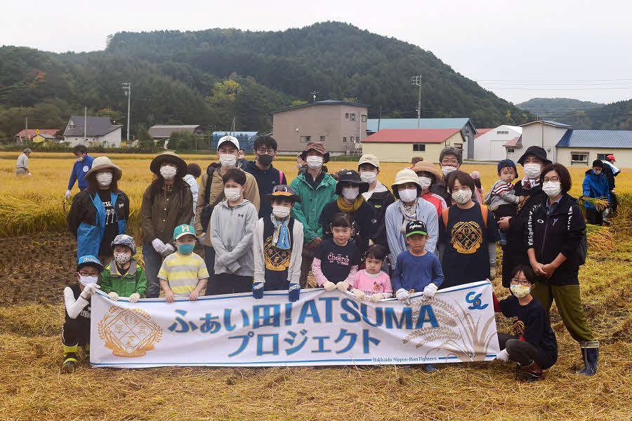 「ふぁい田！ATSUMAプロジェクト」厚真町での稲刈り体験を行った参加者たち（球団提供）