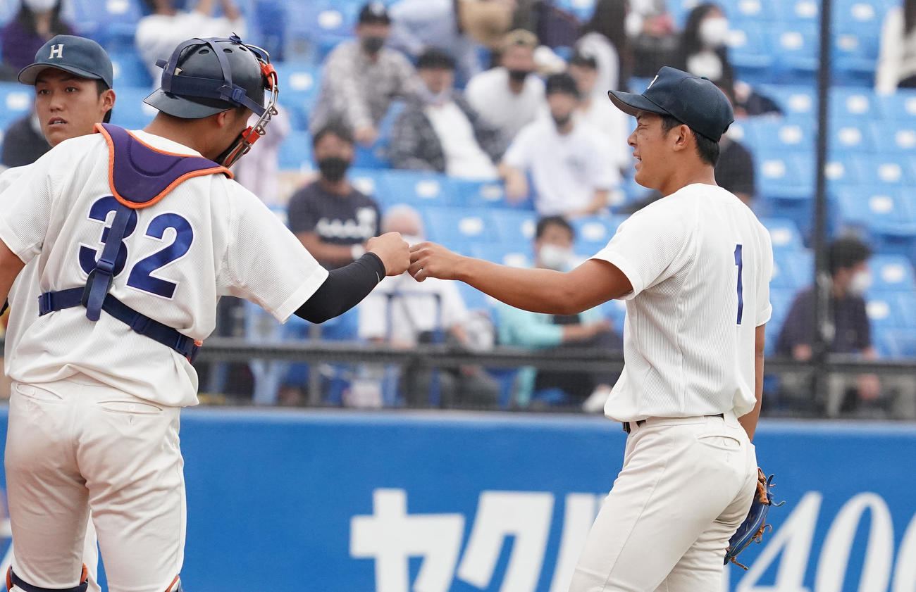 法大対早大　8回途中から登板し、引き分けに終わった法大・鈴木(右）は、厳しい表情で捕手とタッチをする（撮影・菅敏）