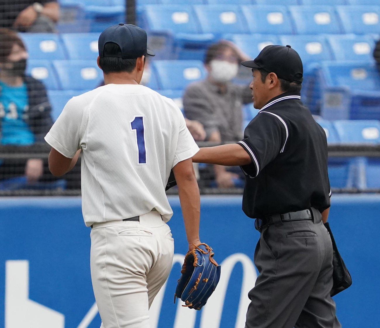 法大対早大　8回、このイニングを投げ終えた法大・鈴木は、早大・福本の二塁打の判定について球審と話しながら降板する（撮影・菅敏）