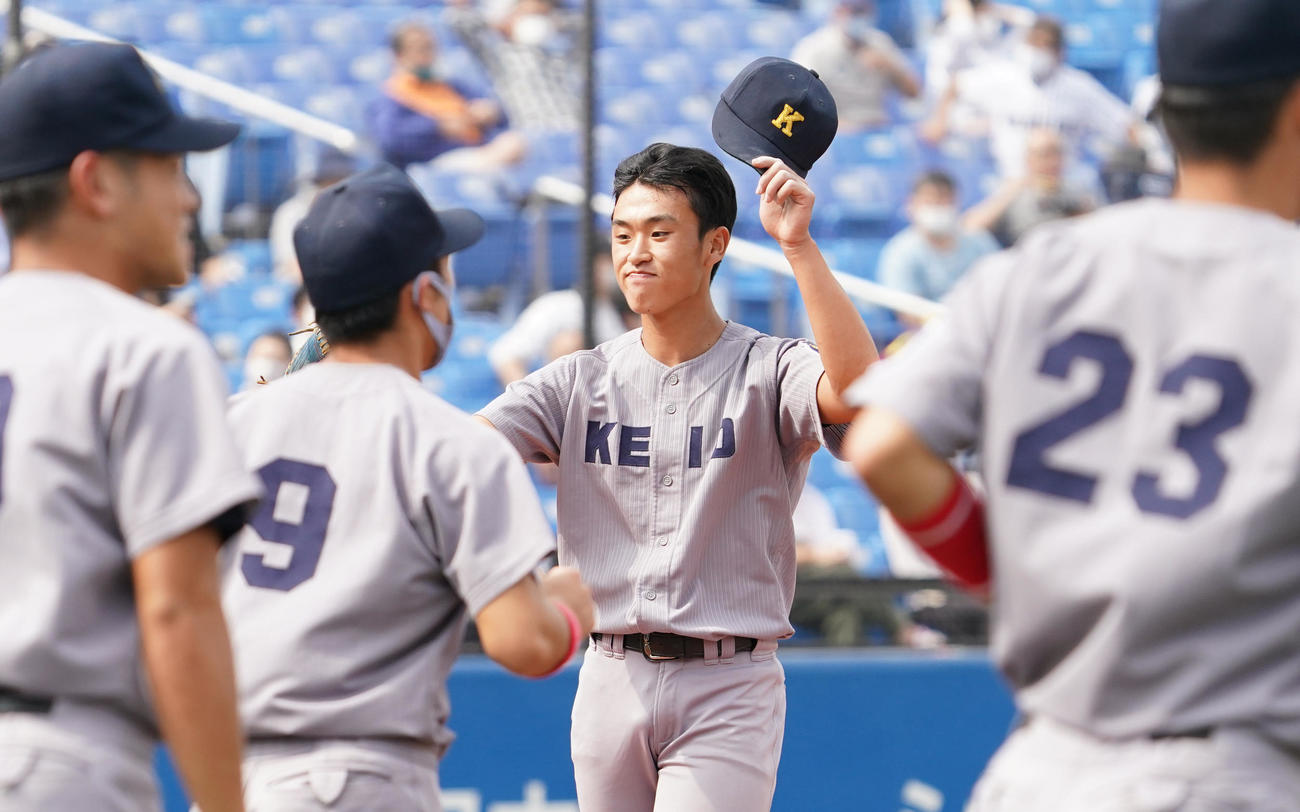 立大に勝利し、最後を締めくくった慶大・生井（中央）は、ナインとタッチをする（撮影・菅敏）