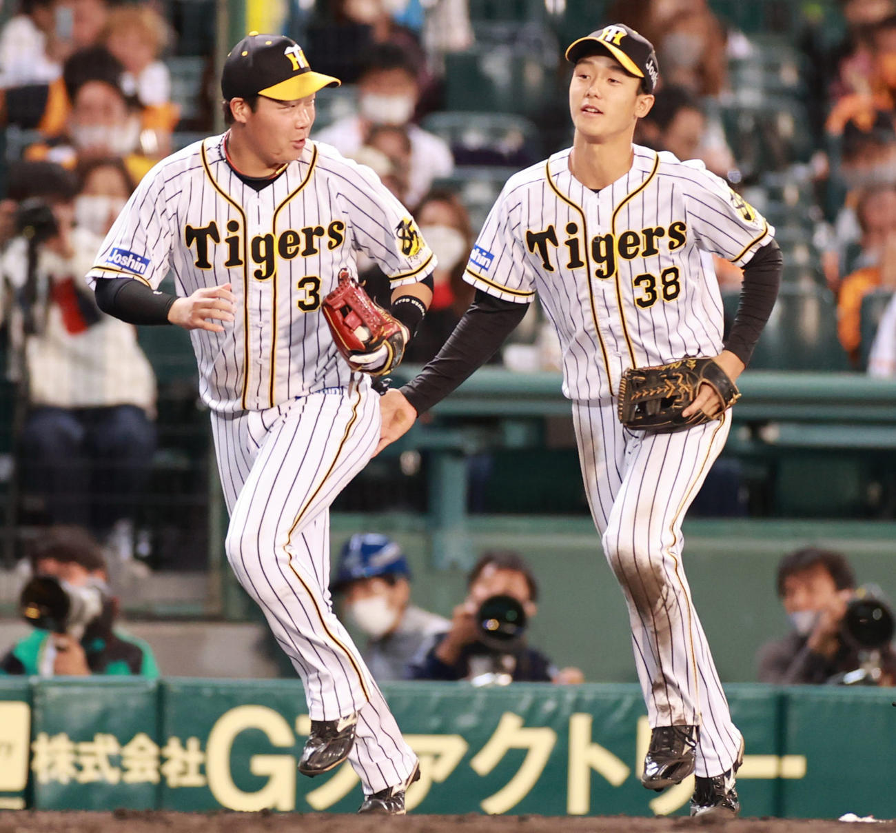 阪神対巨人　6回表巨人2死、吉川尚輝の邪飛を捕った三塁手大山悠輔（左）がカバーに入った遊撃手小幡竜平とぶつかりそうなり笑顔をみせる（撮影・清水貴仁）