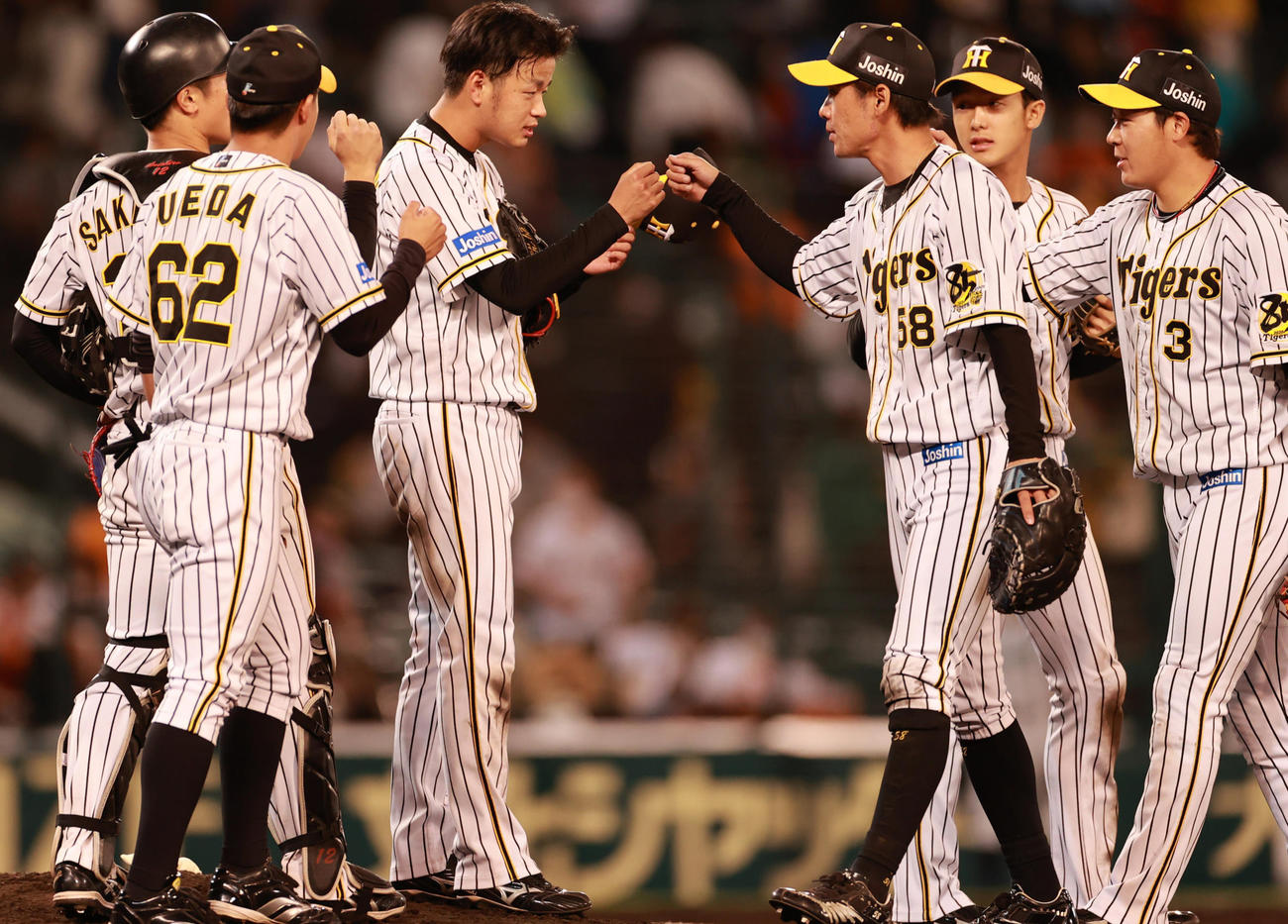 阪神対巨人　完投勝利をあげチームメートとタッチを交わす高橋遥人（中央）（撮影・清水貴仁）
