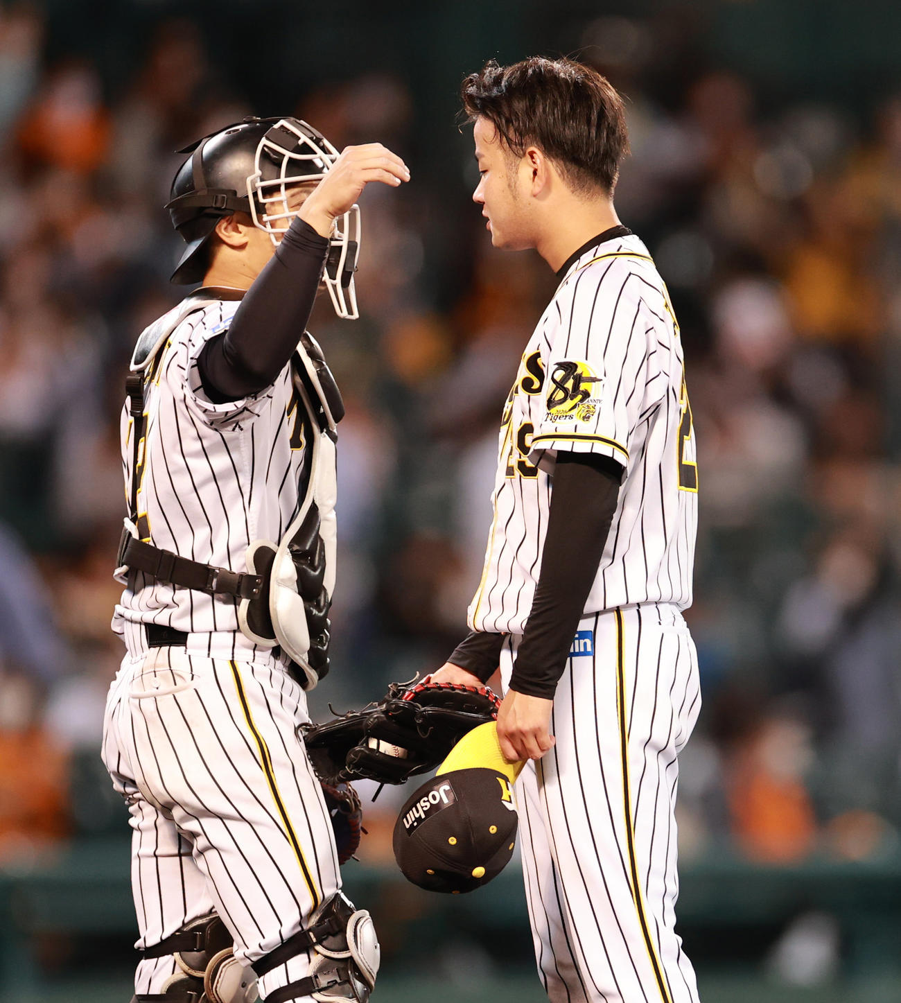 阪神対巨人　完投勝利をあげ捕手の坂本誠志郎（左）からウイニングボールを受け取る高橋遥人（撮影・清水貴仁）