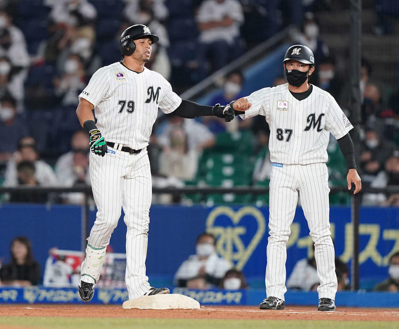 ロッテ対オリックス　7回裏ロッテ無死、中前打を放ったマーティン（左）は根元コーチとタッチを交わす（撮影・鈴木みどり）