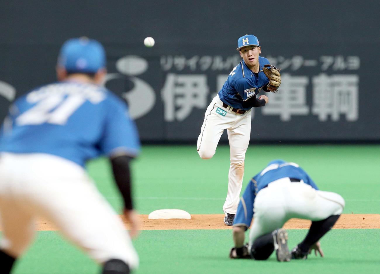 日本ハム対楽天　4回表楽天1死満塁、日本ハム遊撃手平沼からの送球を捕球ミスする一塁手清宮（左手前）（撮影・佐藤翔太）
