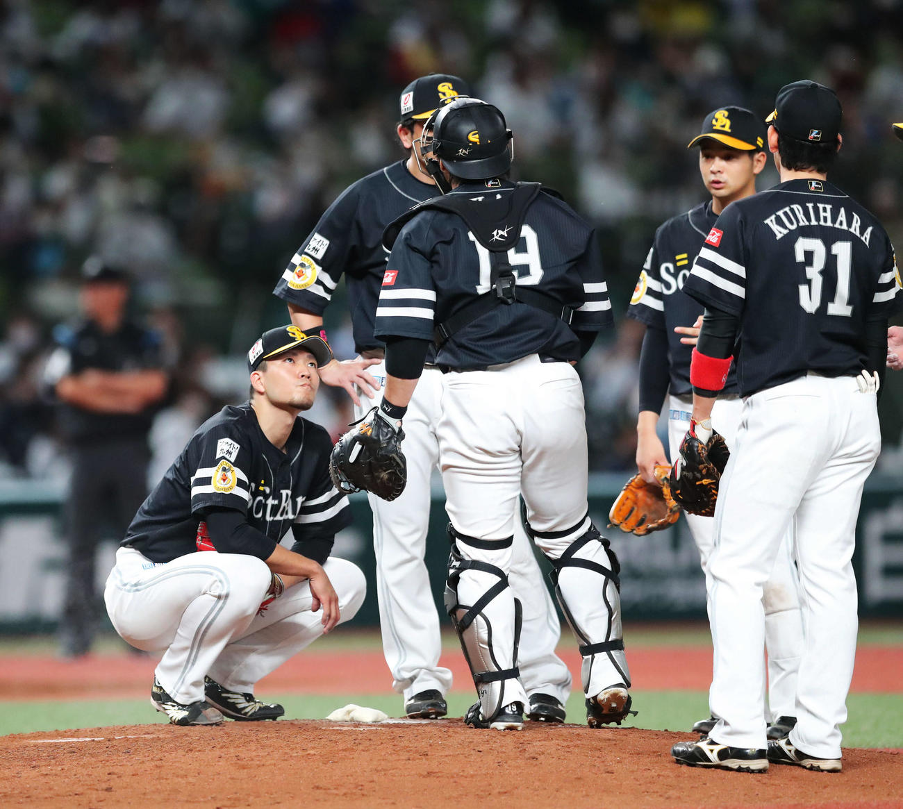 西武対ソフトバンク　5回裏西武1死満塁、マウンドに集まるナインの隅でしゃがみ込む千賀（左）（撮影・河田真司）