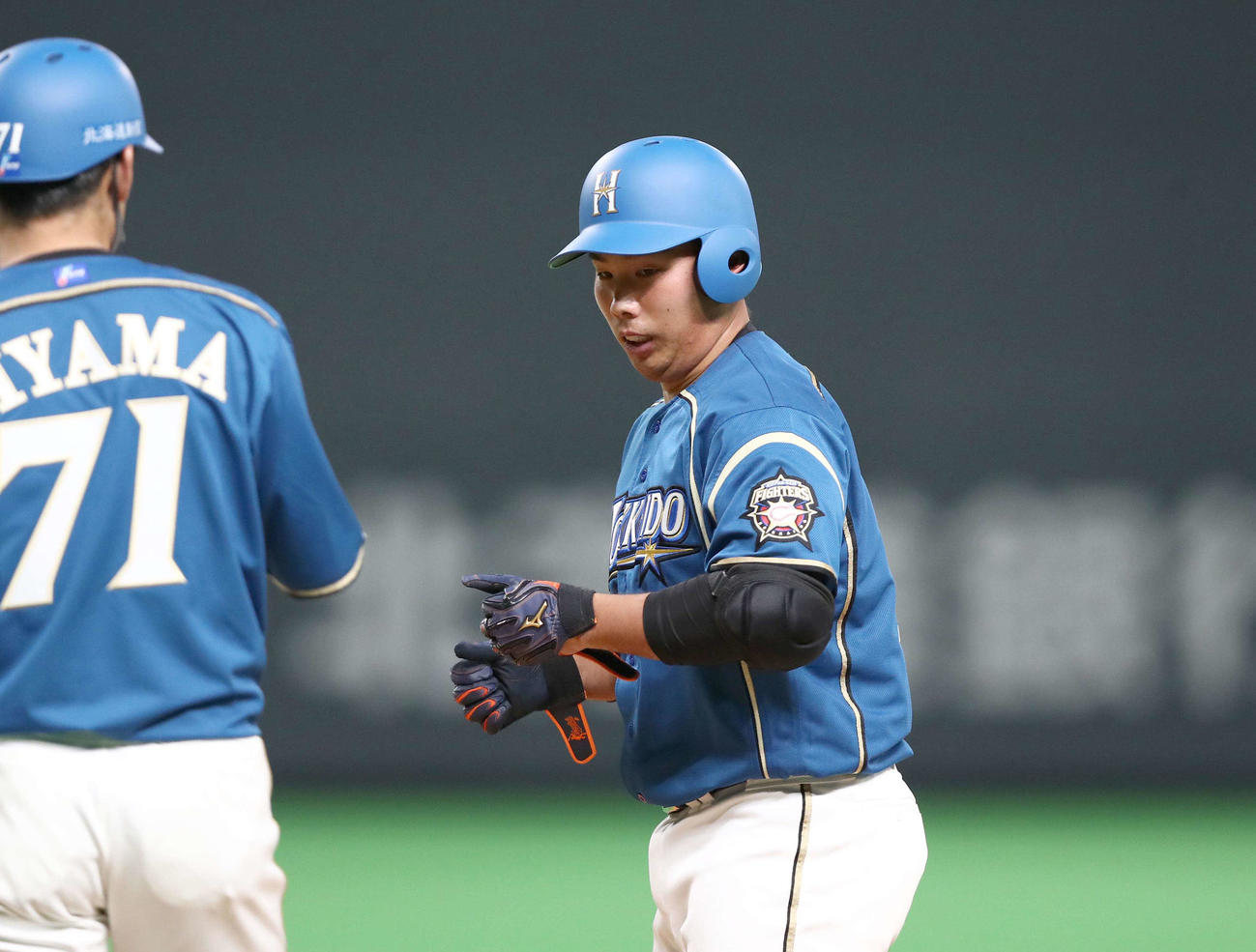 日本ハム対楽天　5回裏日本ハム無死、左前打を放ち飯山コーチとタッチする樋口（撮影・黒川智章）
