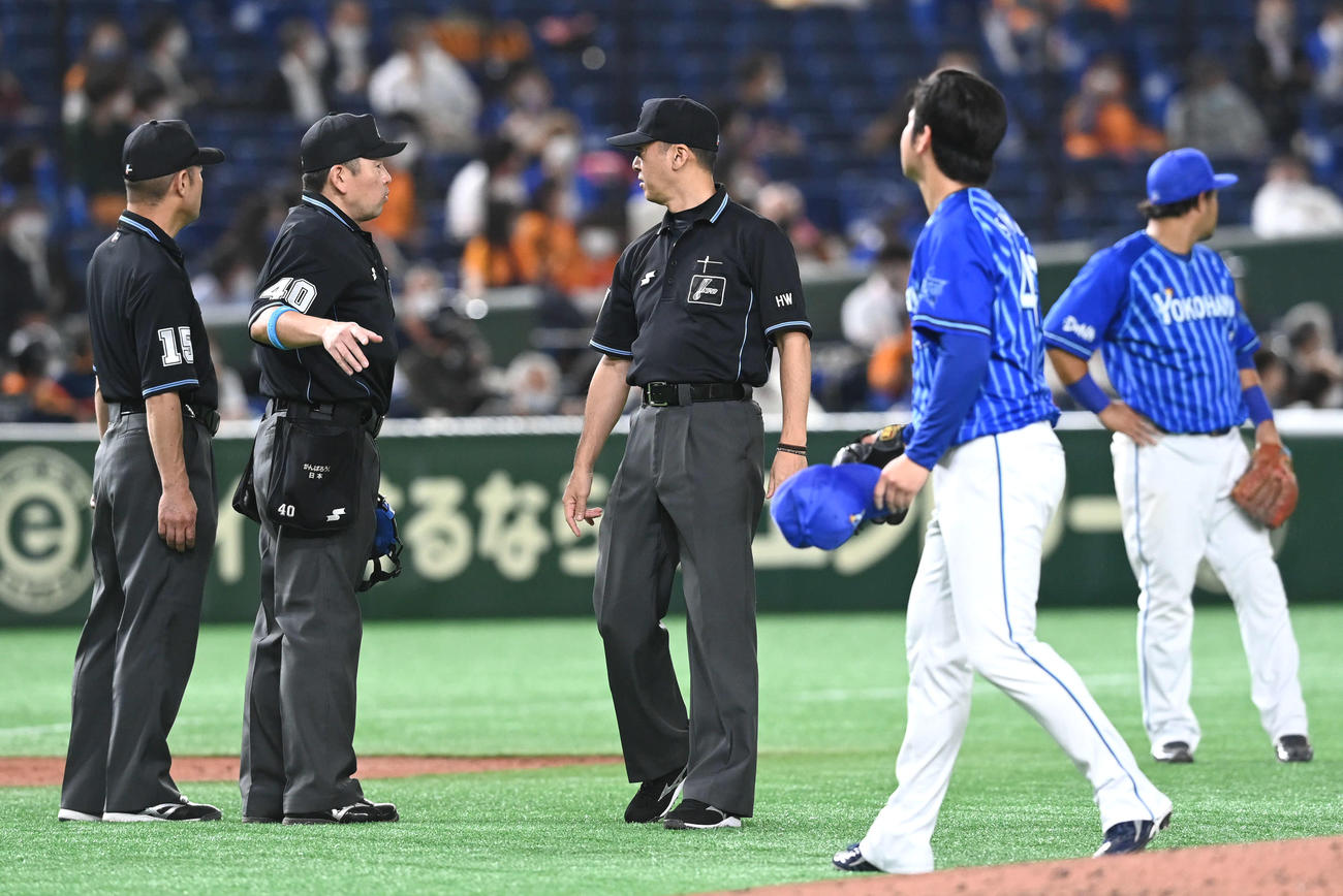 3回裏巨人無死一塁、左翼席に反射物があるとして試合を止めて協議する審判団（撮影・山崎安昭）
