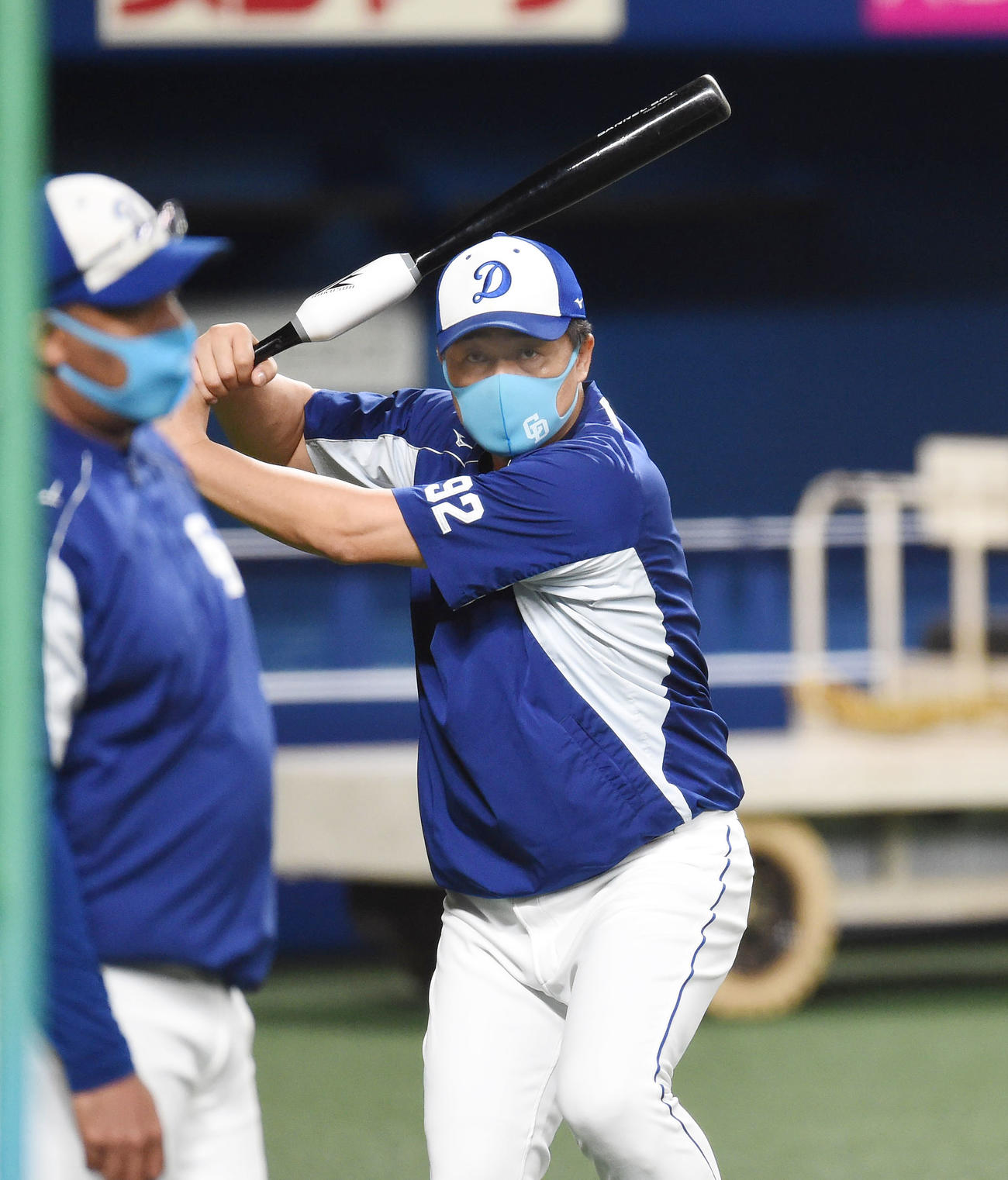 バットを手に鋭い目線で素振りをする与田監督（撮影・森本幸一）