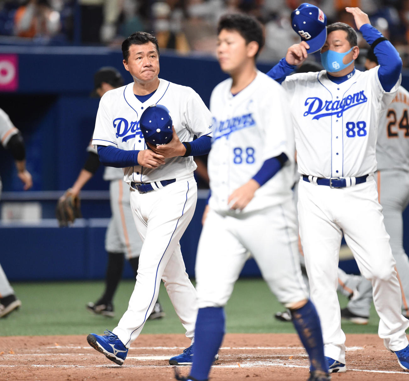 中日対巨人　記念試合に敗れ無念な表情で引き揚げる与田監督（左）ら（撮影・森本幸一）