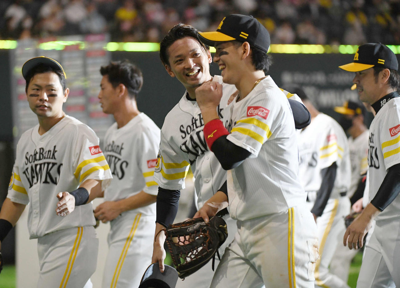 ソフトバンク対ロッテ　7勝目を挙げた東浜（中央左）は栗原（同右）と笑顔でベンチに戻る。左は中村晃（撮影・今浪浩三）