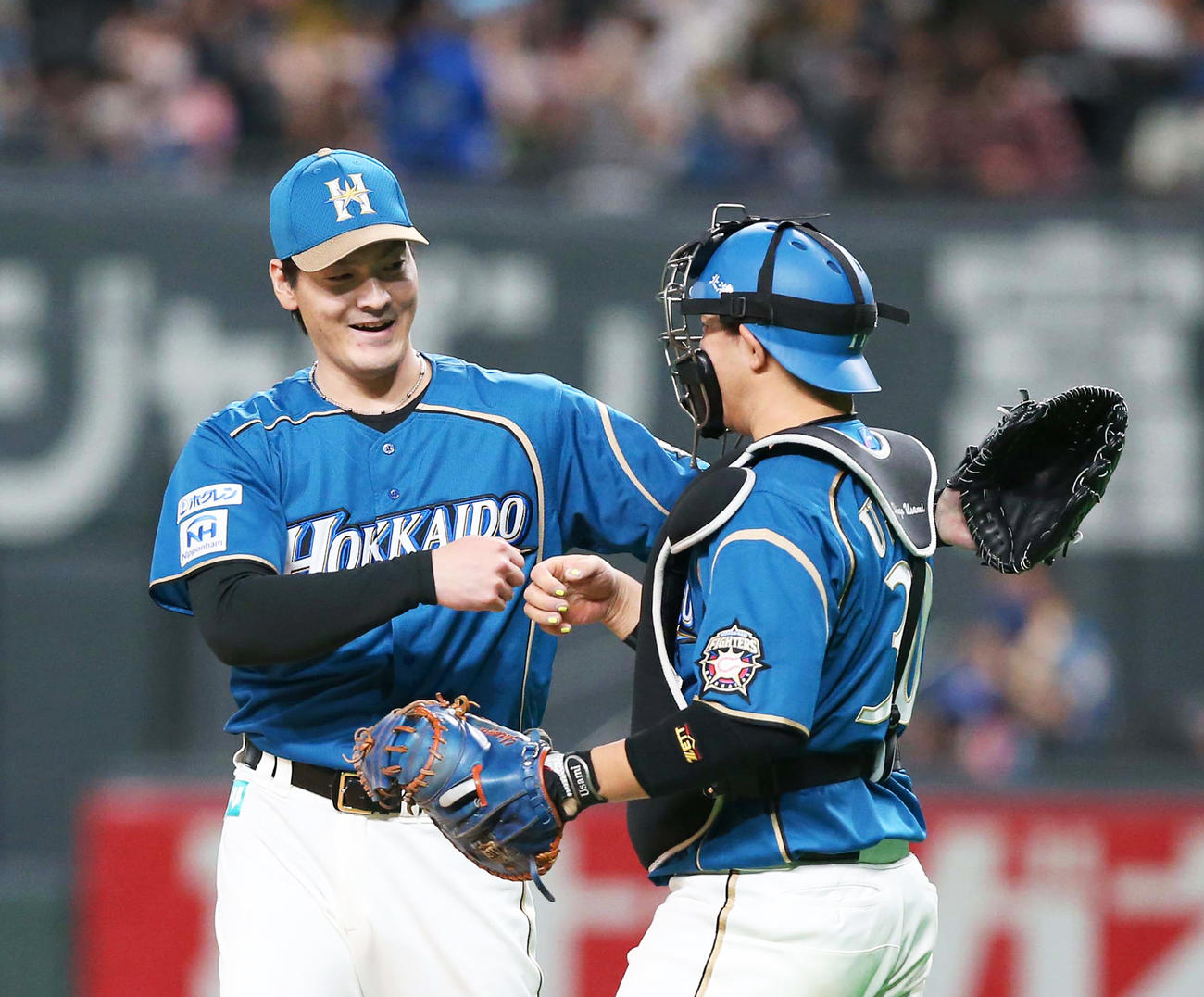 今季初完封勝利を挙げ宇佐見（右）とタッチする有原（撮影・黒川智章）