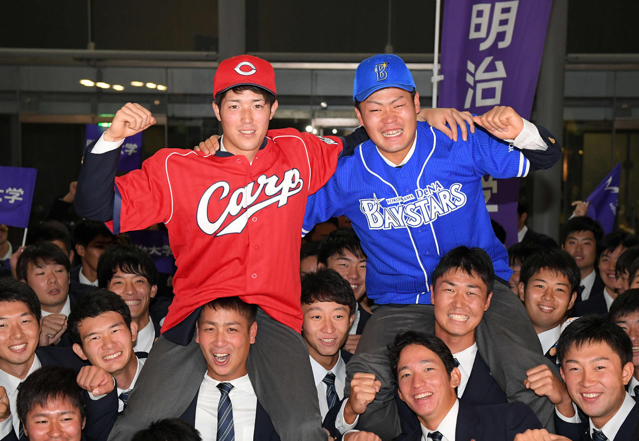 19年10月、明大ナインに肩車で祝福される、広島1位指名の森下（左）とDｅNA3位指名の伊勢