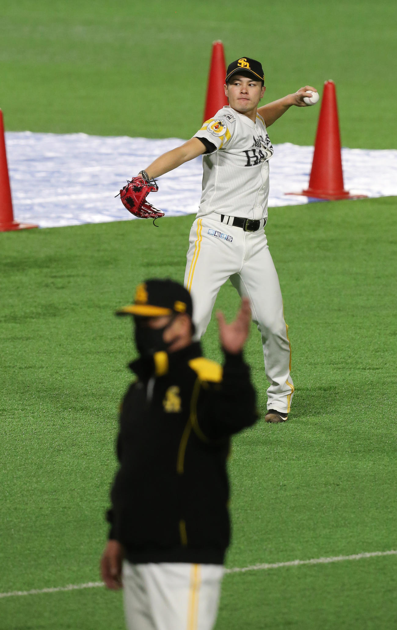 投手練習を視察した工藤公康監督（手前）の前で、キャッチボールを行う笠谷俊介（撮影・菊川光一）