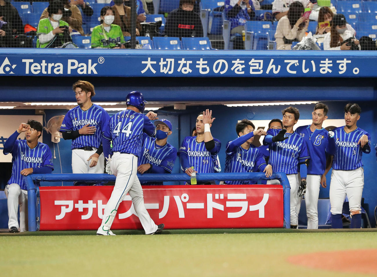 ヤクルト対DeNA　6回表DeNA無死二塁、勝ち越しの2点本塁打を放ち、生還した佐野（右）はベンチナインに出迎えられる（撮影・河田真司）