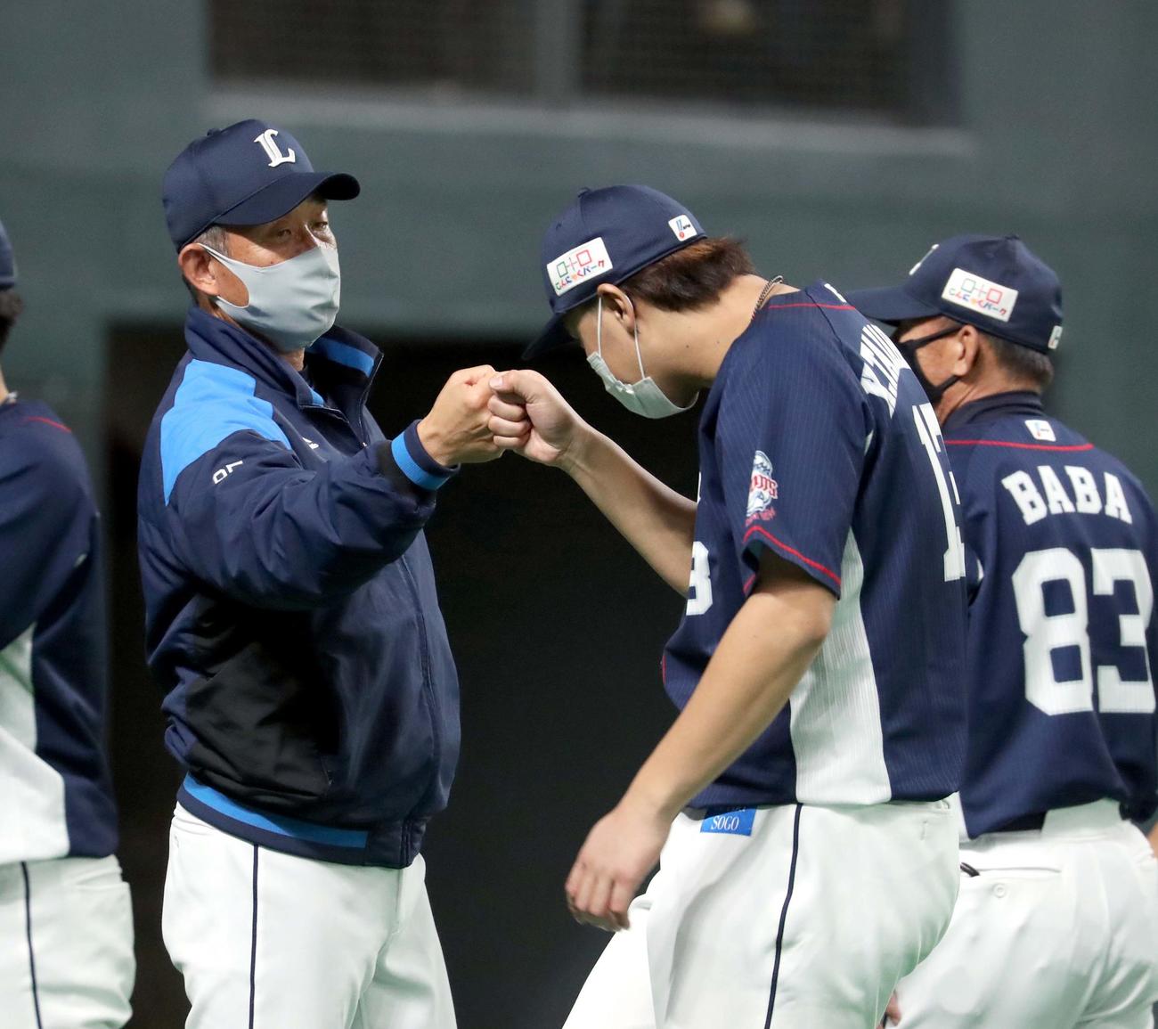 日本ハム対西武　試合後、西武辻監督（左奥）は高橋光を出迎えグータッチを交わす（撮影・佐藤翔太）