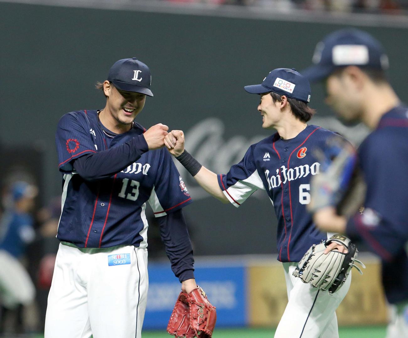 日本ハム対西武　8回裏を無失点に抑えグータッチを交わす西武高橋光（左）と源田（撮影・佐藤翔太）