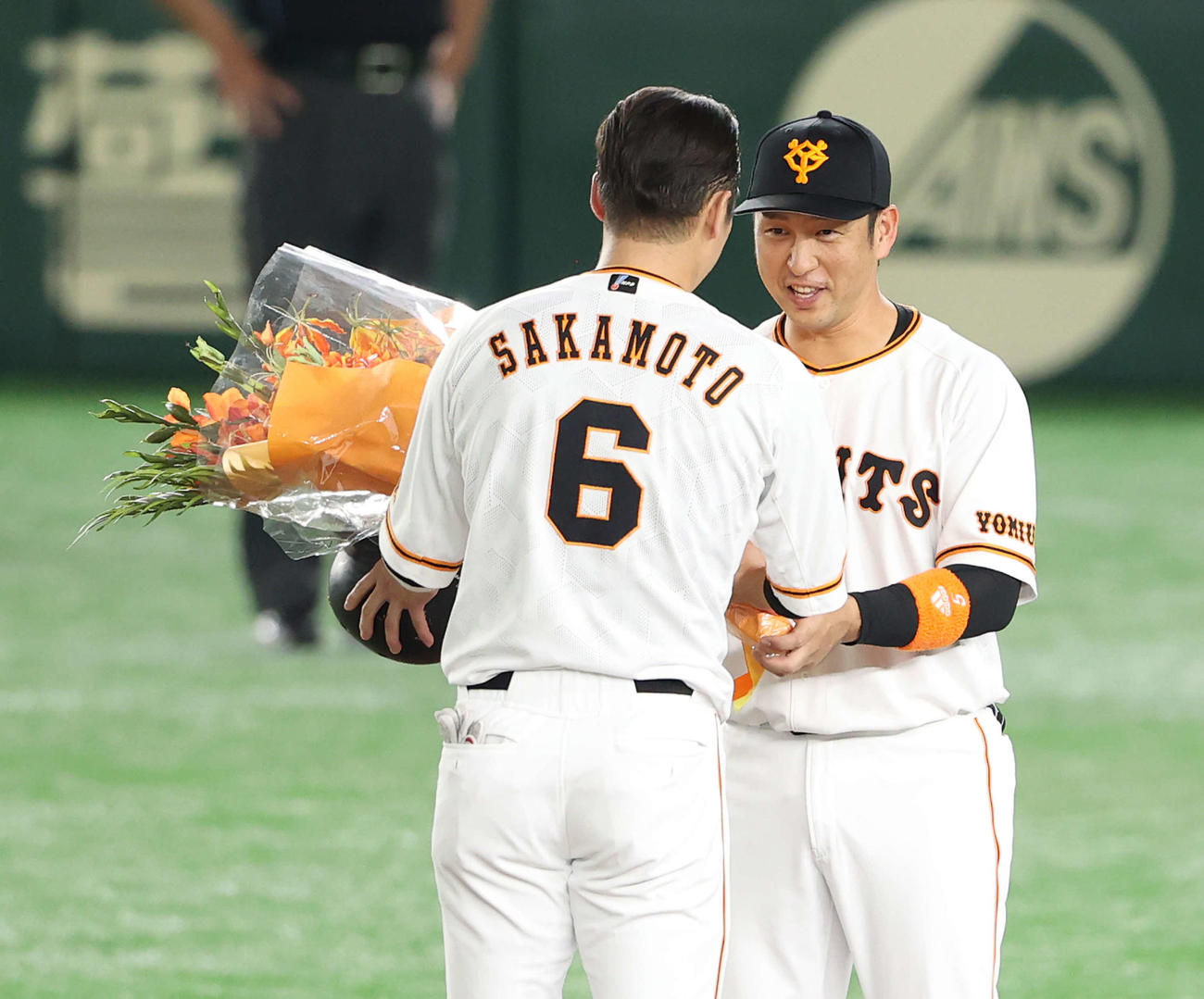 巨人対ヤクルト　1回裏巨人2死、プロ通算2000安打を達成した坂本（手前）に花束を渡す中島（撮影・河野匠）
