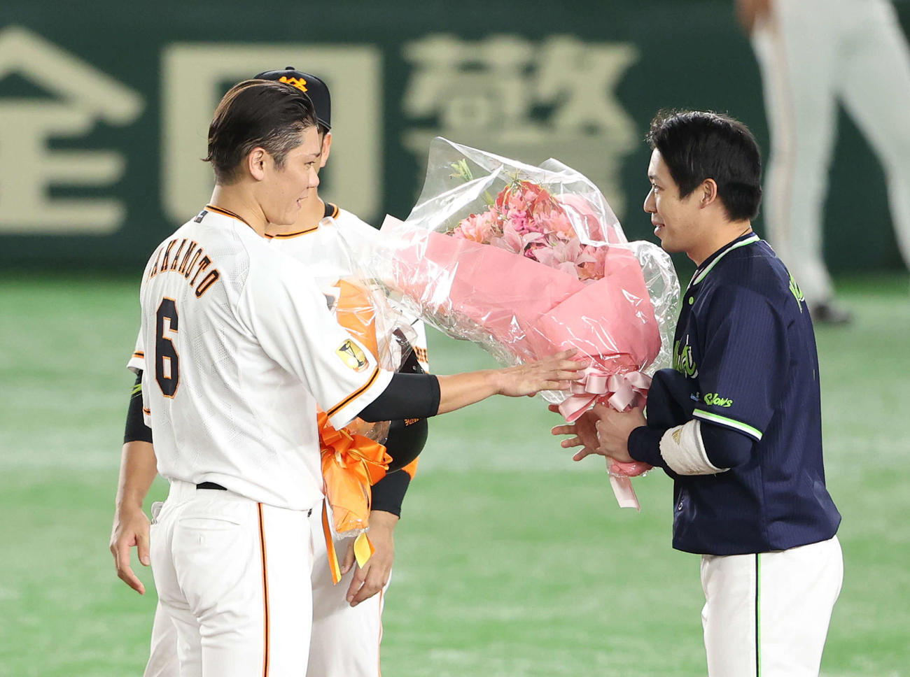 巨人対ヤクルト　1回裏巨人2死、プロ通算2000安打を達成した坂本（左）に花束を手渡すヤクルト山田哲（撮影・河野匠）
