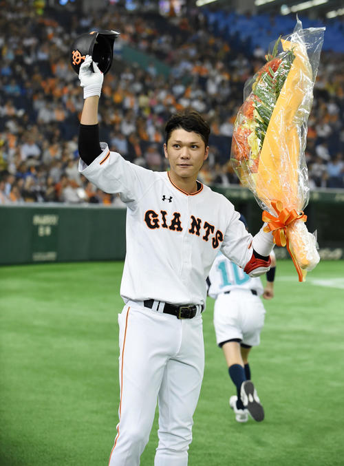 巨人対DeNA　1回裏巨人2死、通算150本塁打を放ち花束を手に声援に応える坂本（撮影・横山健太）