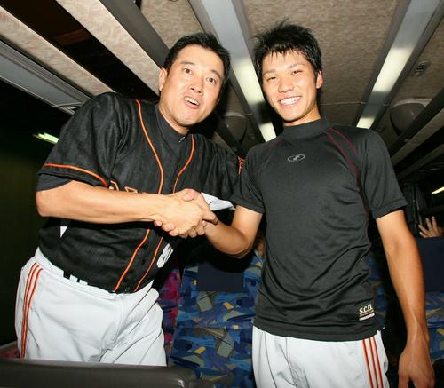 バスに乗り込む坂本勇人は原辰徳監督（左）と握手し笑顔を見せる（2007年09月06日撮影）