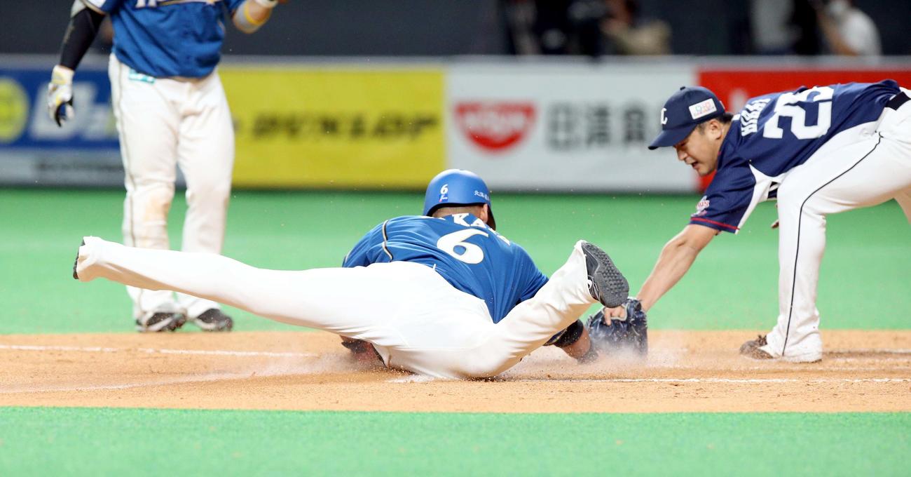 日本ハム対西武　4回裏日本ハム2死二塁、西武平井（右）の暴投で森捕手が後逸する間に本塁に頭から生還する二塁走者の中田（撮影・佐藤翔太）