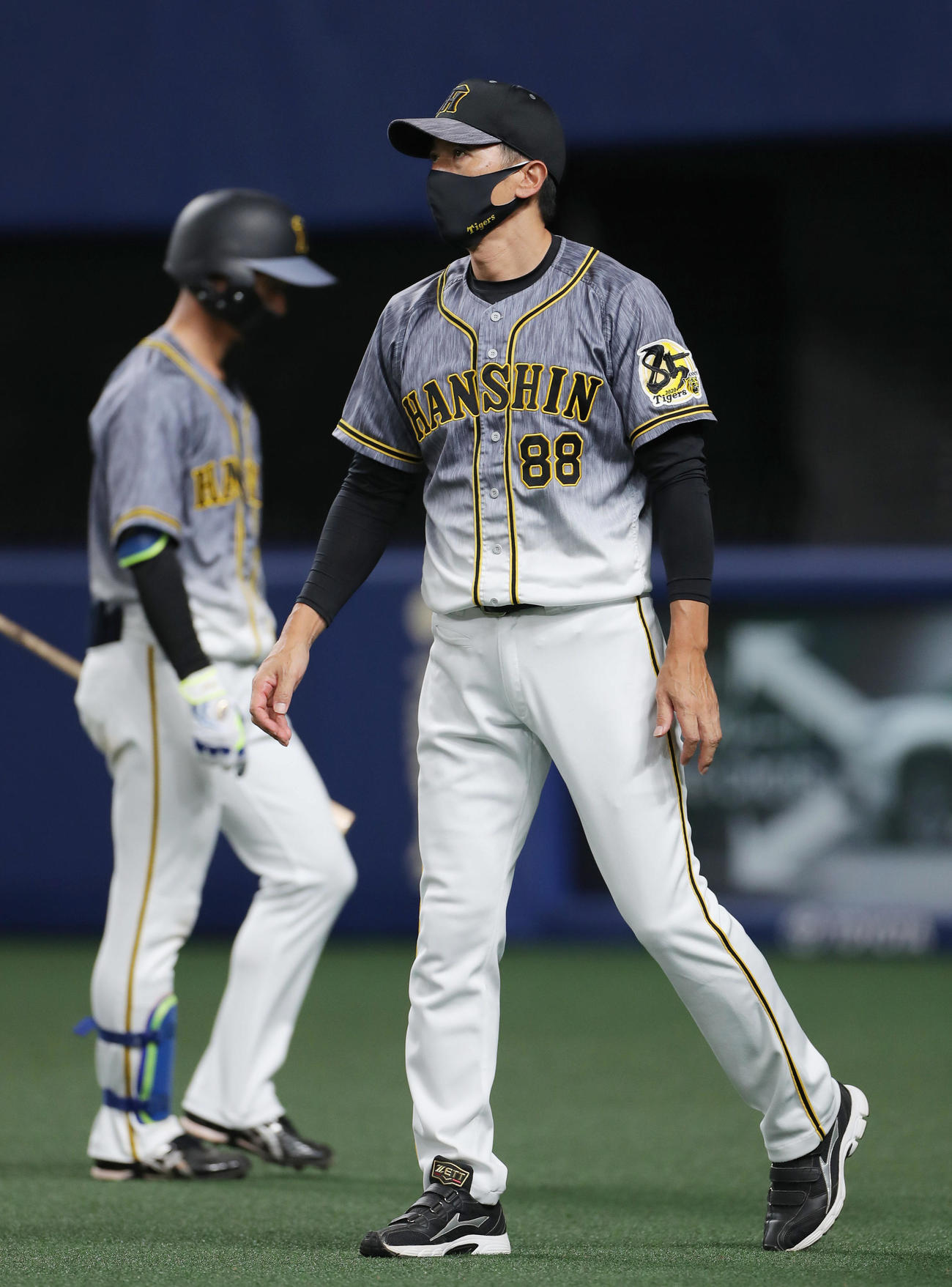 中日対阪神　8回、選手交代を告げる矢野監督。後方は凡退しベンチへ戻る近本（撮影・前田充）