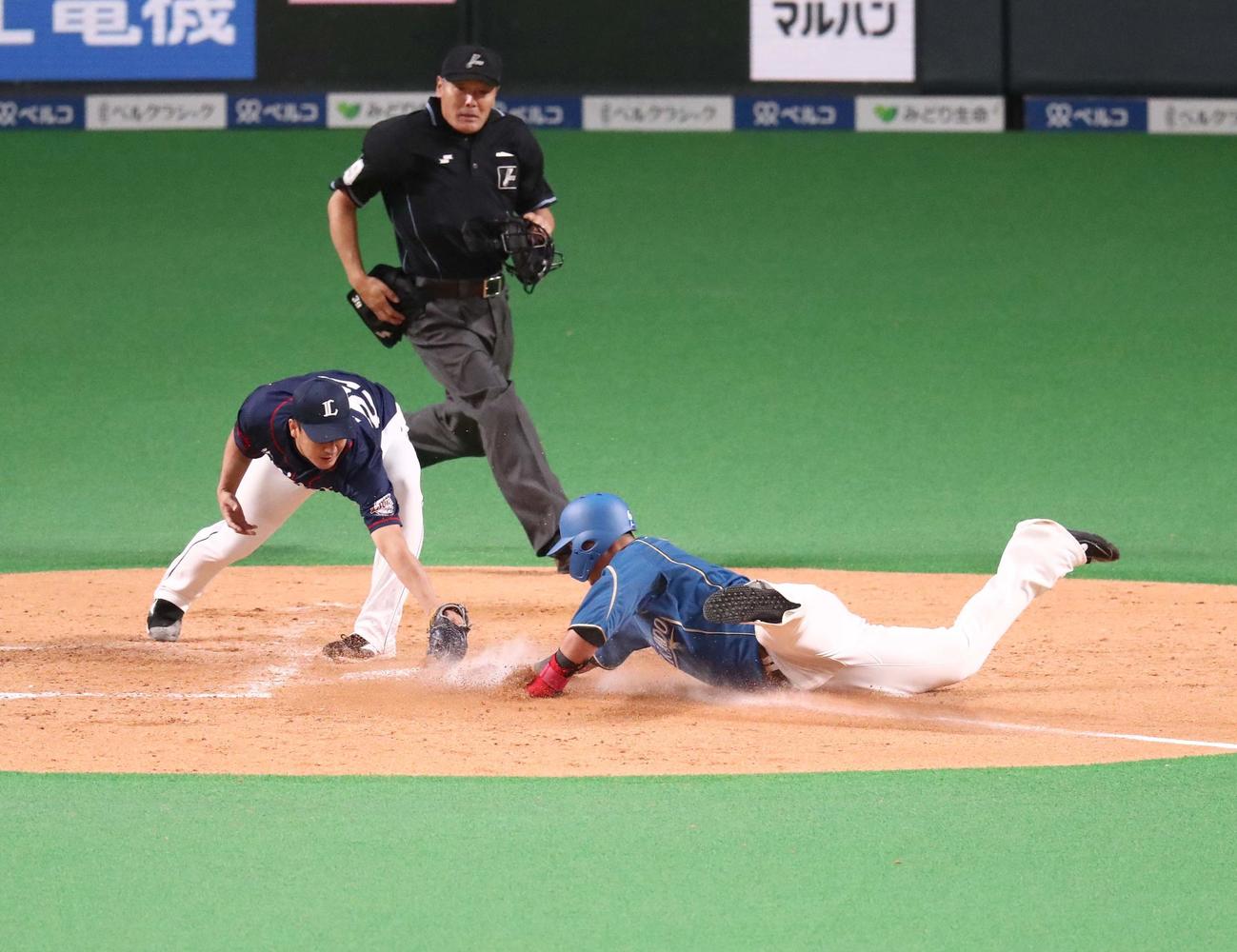 日本ハム対西武　4回裏日本ハム2死二塁、平井の暴投の間に本塁に生還する中田（撮影・黒川智章）