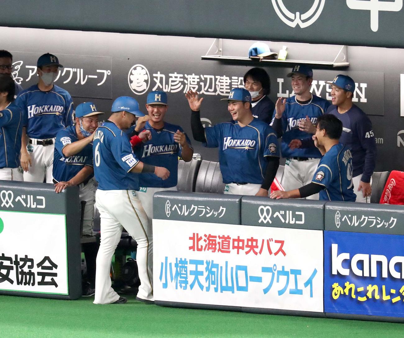 日本ハム対西武　4回裏日本ハム2死二塁、平井の暴投で本塁に生還した中田を出迎えるナイン（撮影・黒川智章）