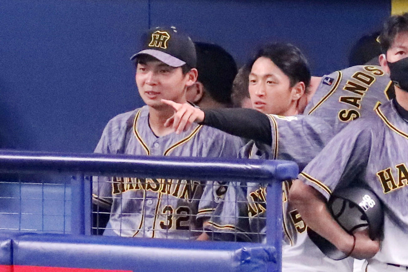 中日対阪神　井上（左）にベンチでアドバイスする近本（撮影・加藤哉）